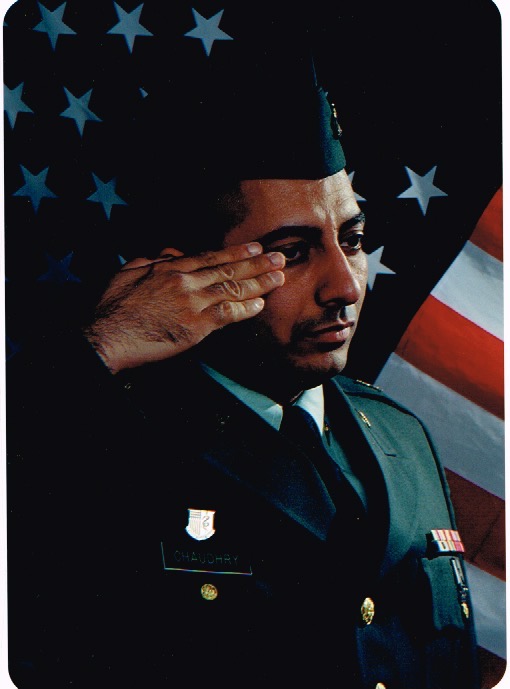 Zahid Chaudhry in U.S. Army dress uniform, saluting before the American flag, 2003